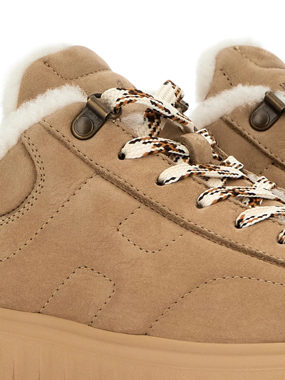 Beige suede sneakers close-up: lace-up with patterned cords and metal eyelets