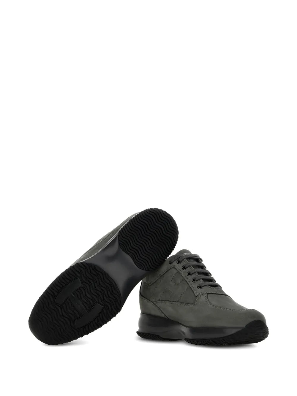 Charcoal grey sneakers with one showing textured tread underside, black outsole