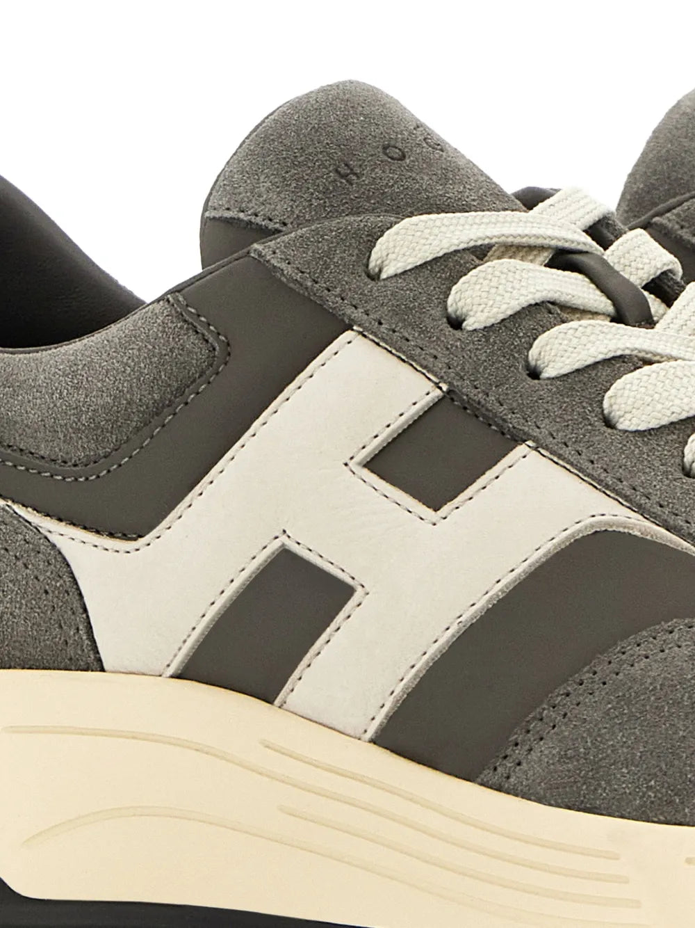 Grey suede upper close-up with white H panel and cream midsole, lace and tongue