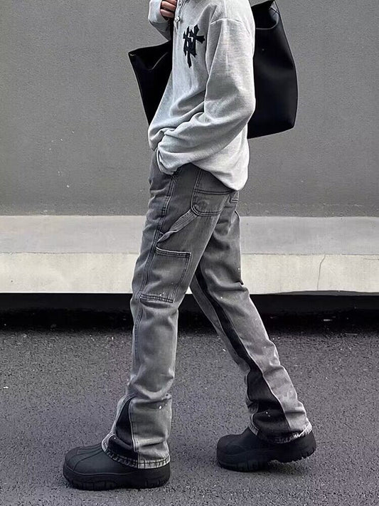 Gray denim jeans, relaxed straight legs with side paint marks and cuffed hem