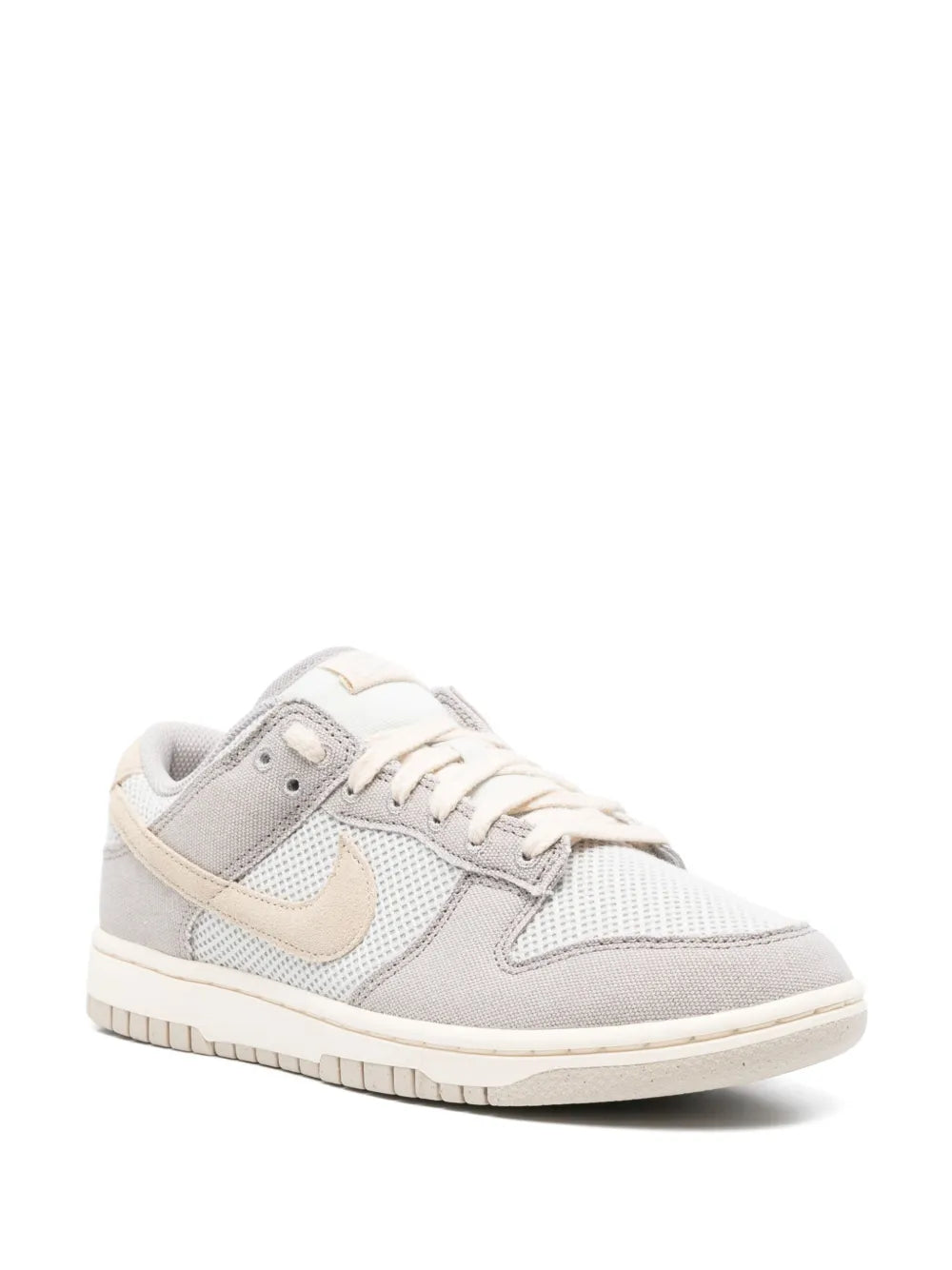 Low-top sneakers side view in light grey and cream, lace-up, textured toe and mesh
