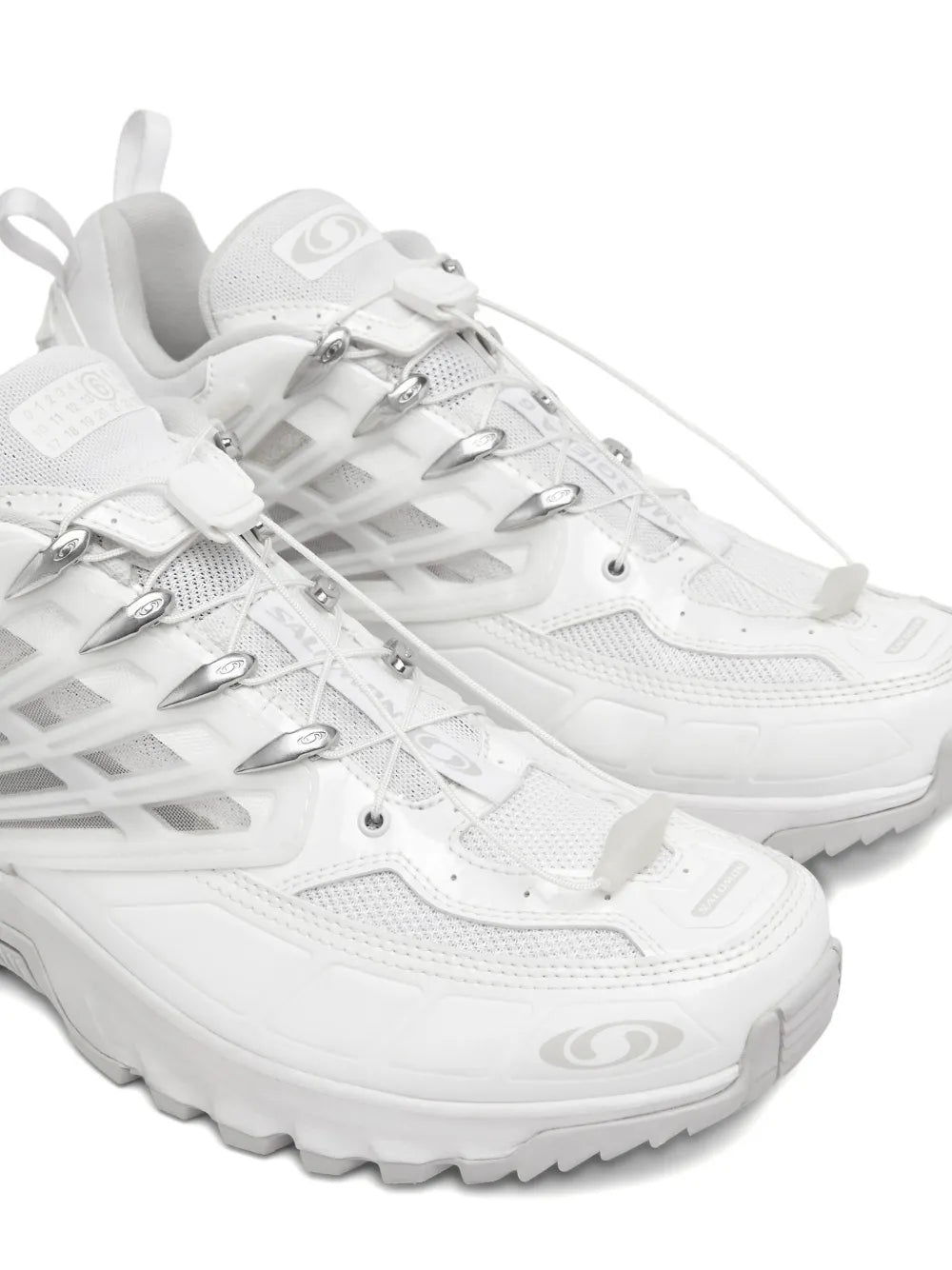 White logo-print sneakers close-up, lace-up upper with metal eyelets and patterned overlays