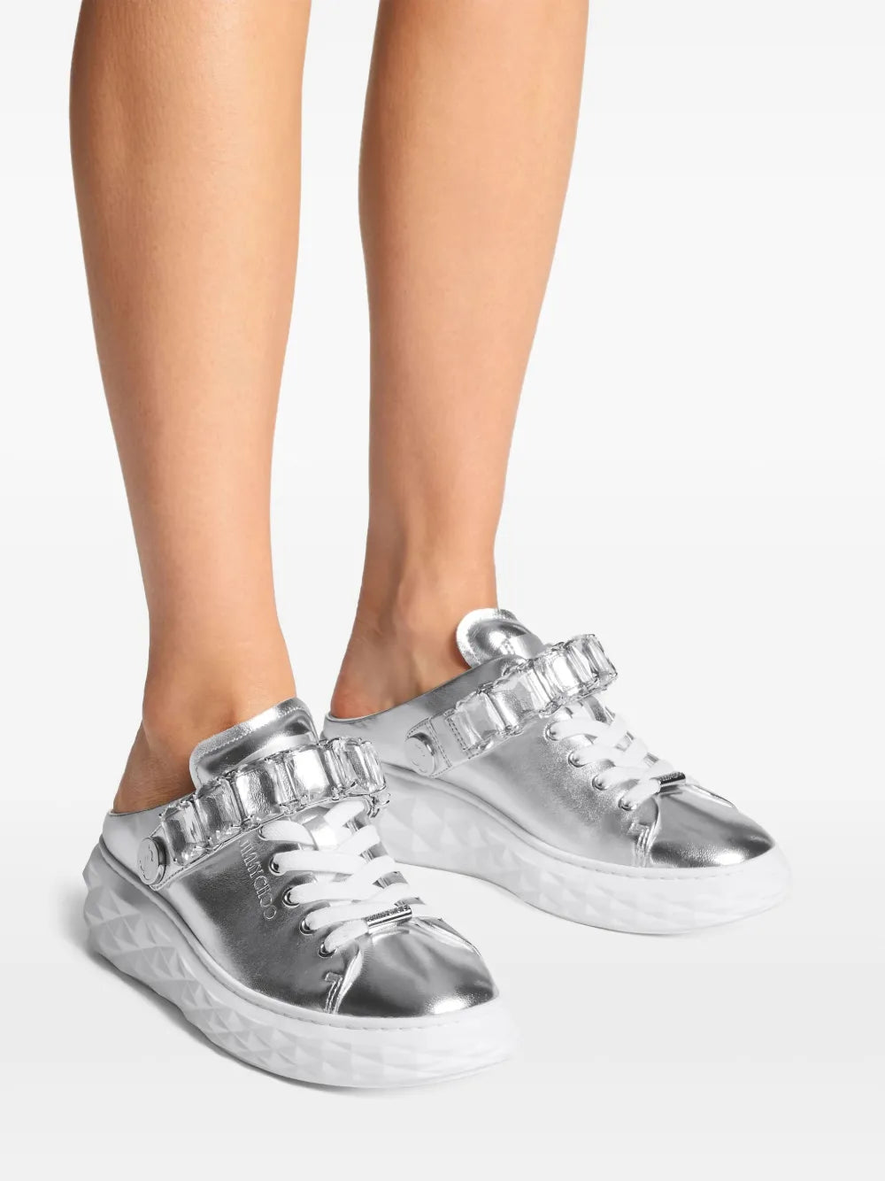 Metallic silver platform sneakers on legs with rhinestone-embellished side strap