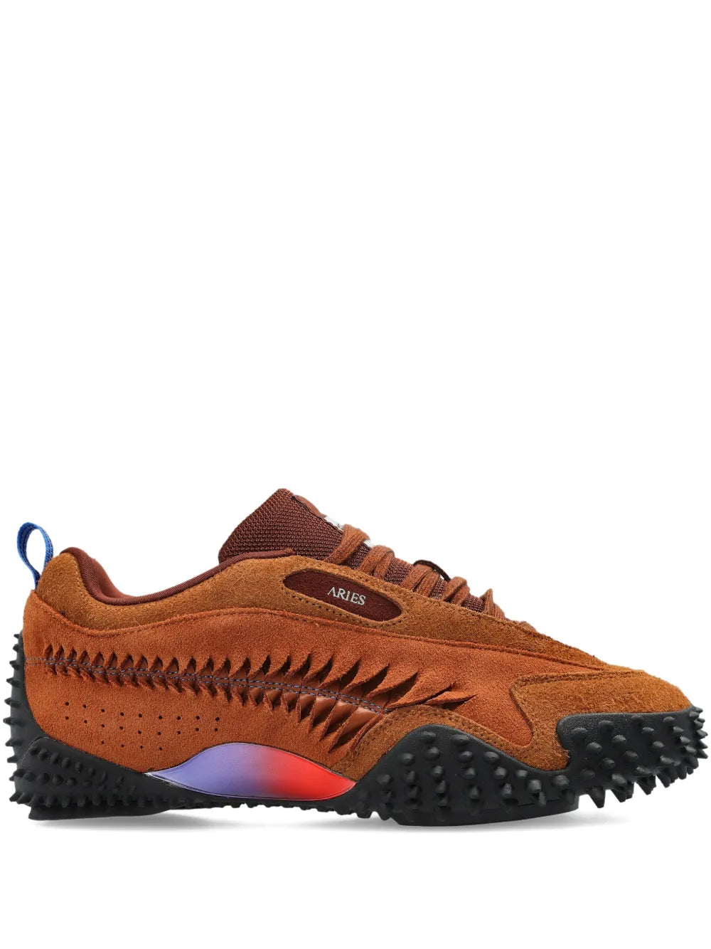 Brown low-top sneaker with blue lace accent and black studded rubber sole