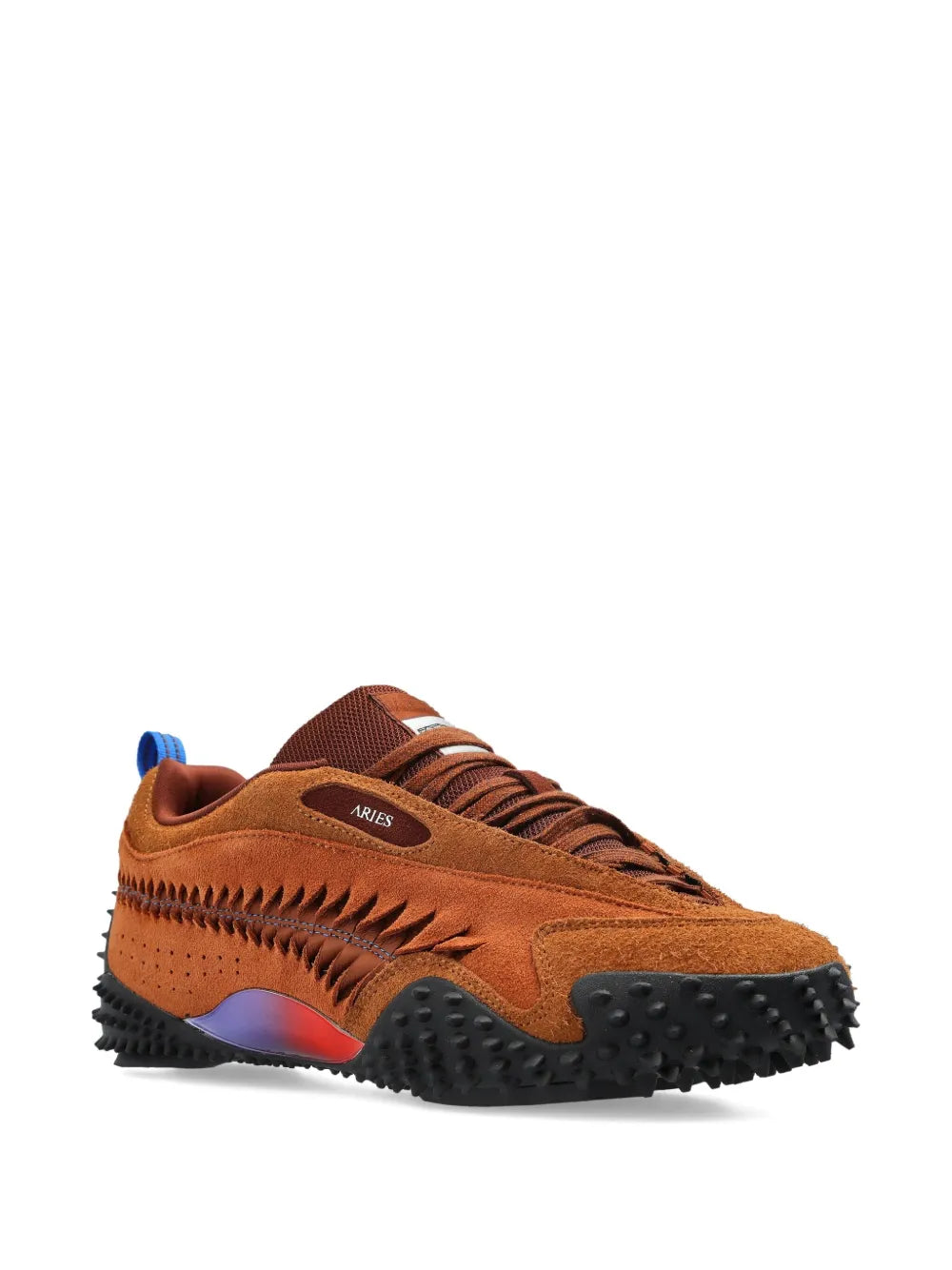 Brown low-top sneaker angled view with black chunky outsole and red side stripe
