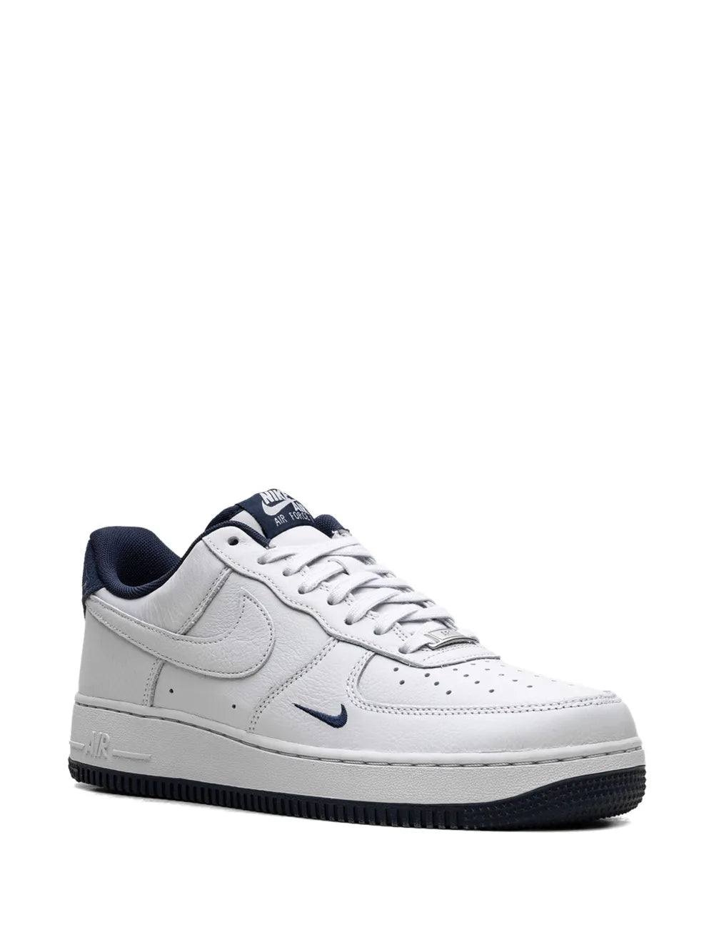 White Nike low-top sneakers with navy Swoosh and lace-up front, padded collar