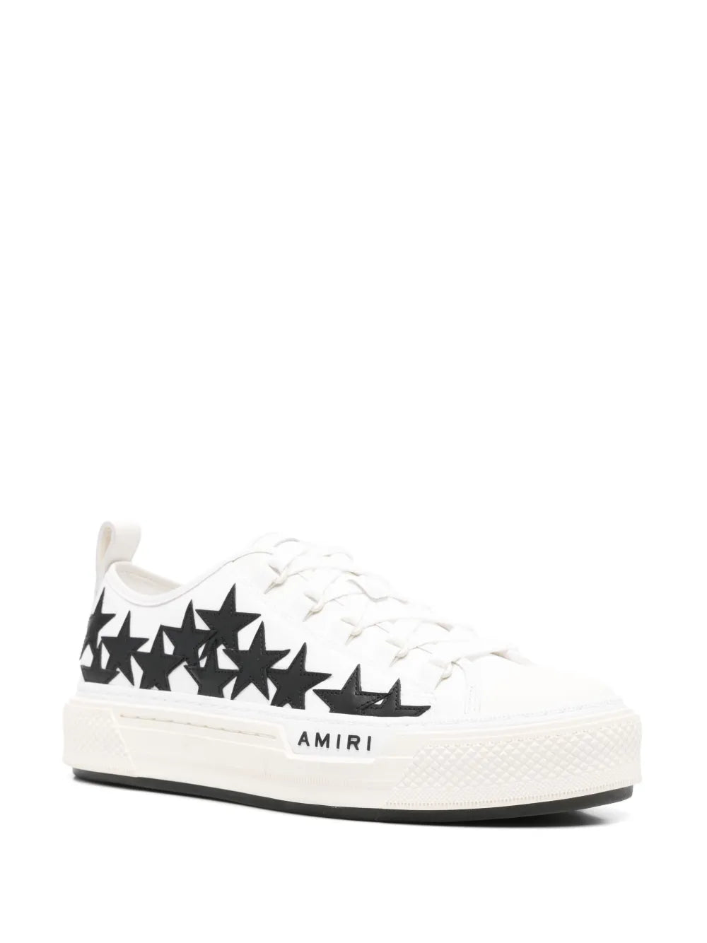 White low-top sneakers with black star print, lace-up front, AMIRI tag