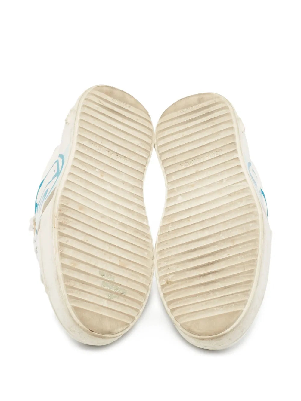 White sneaker outsoles with ribbed tread and blue side emblem