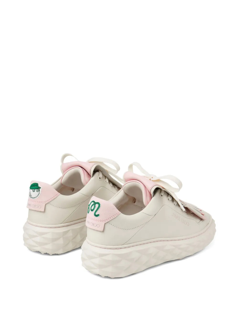 Pair of cream low-top lace-up sneakers with pink tongue patches and chunky sole