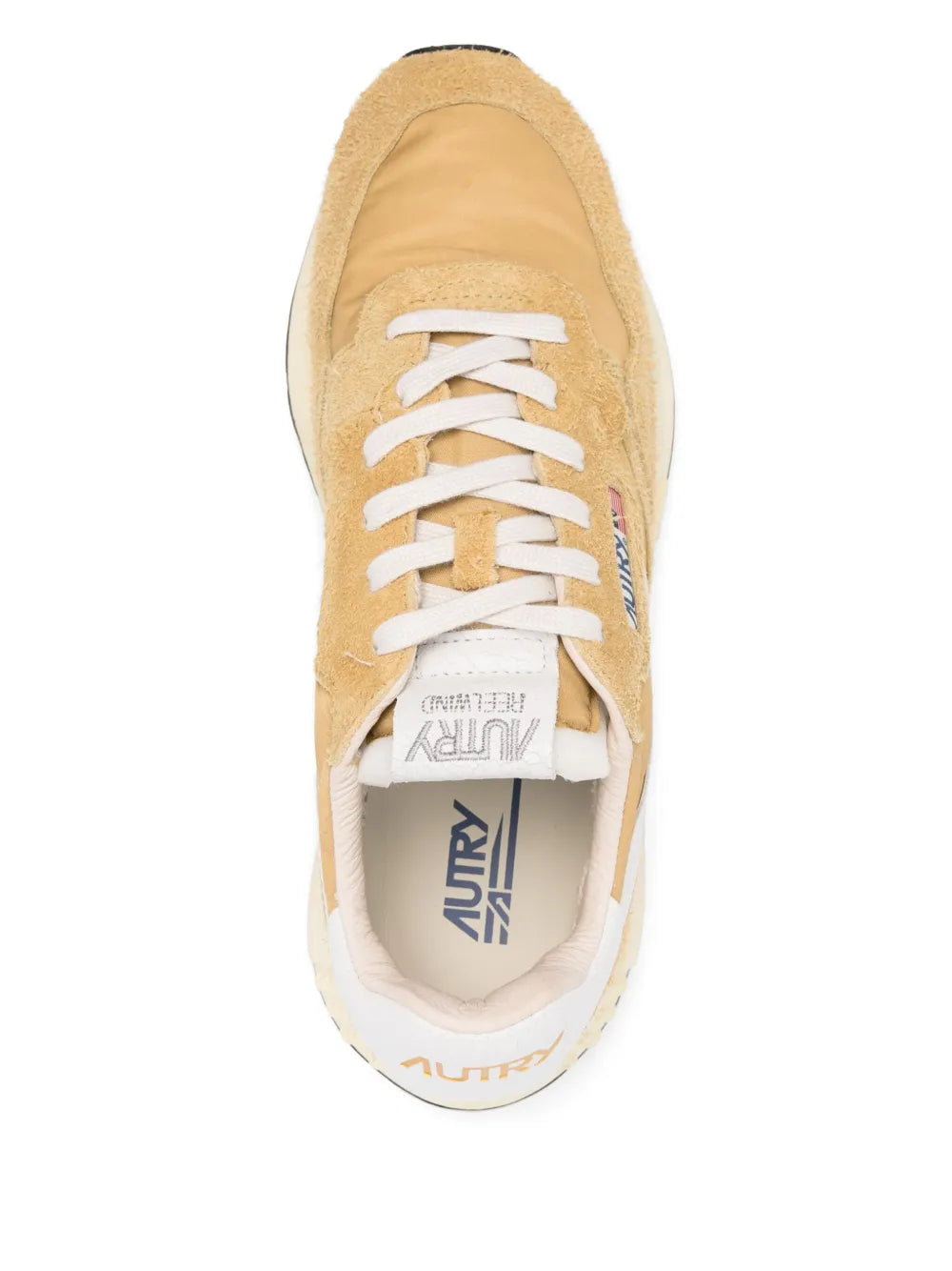 Beige suede sneaker with white laces, tongue label, and padded collar lining