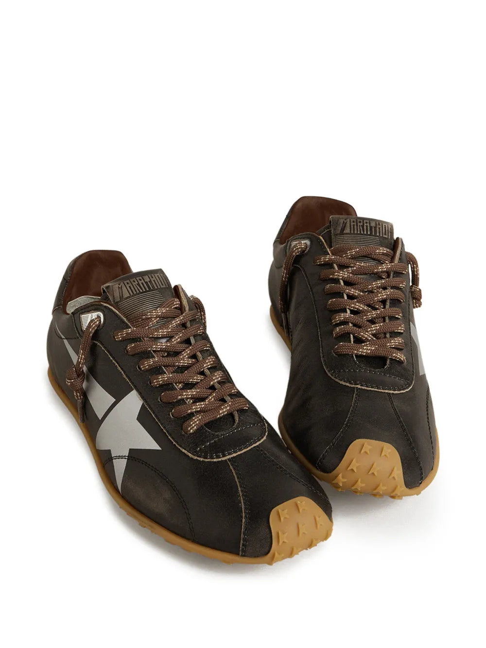 Pair of dark brown leather lace-up sneakers with star patches and tan soles