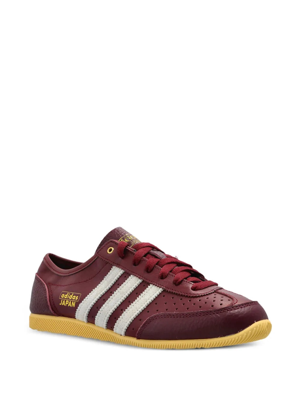 Burgundy adidas low-top sneakers with white stripes and gum outsole.