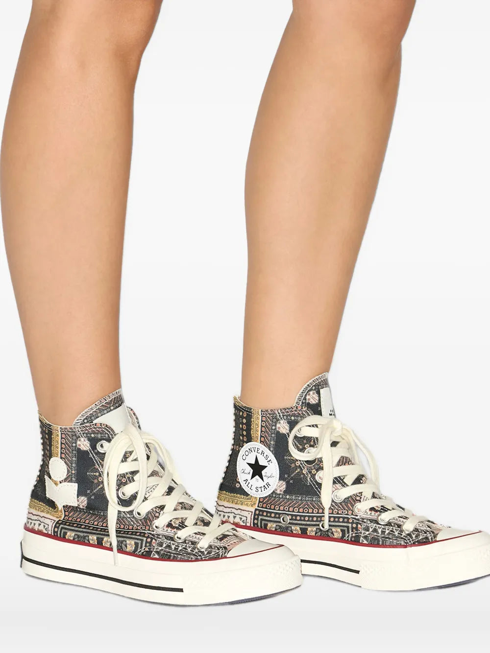 Black patterned high-top sneakers worn, white laces, contrasting rubber sole