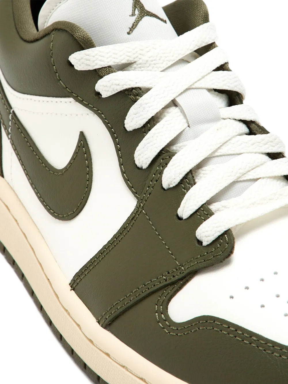 Close-up of Nike Air low-top sneakers: olive green side panel, white Swoosh, laces