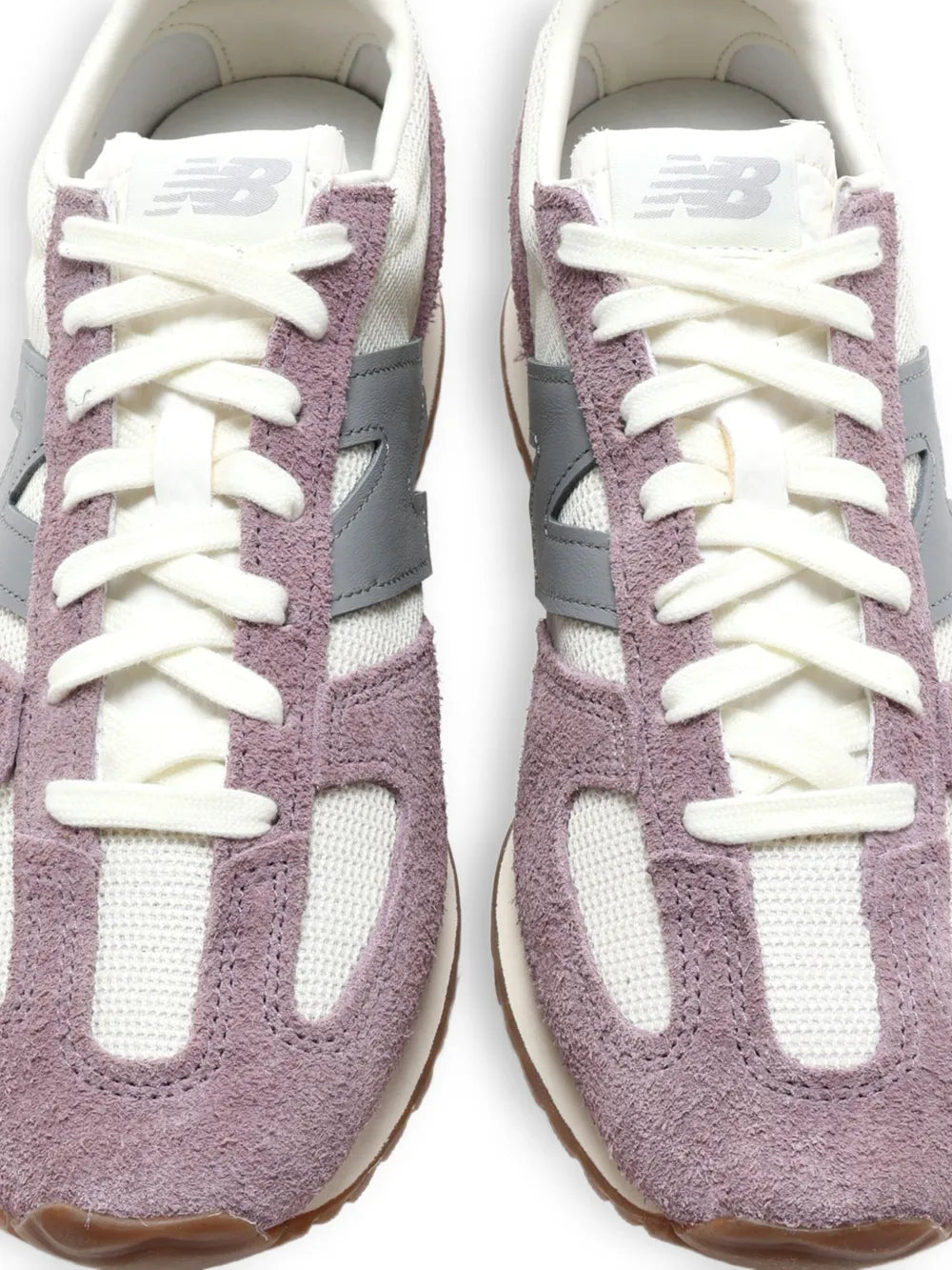 Pair of lace-up sneakers with mauve suede and cream mesh, white laces, NB logo.