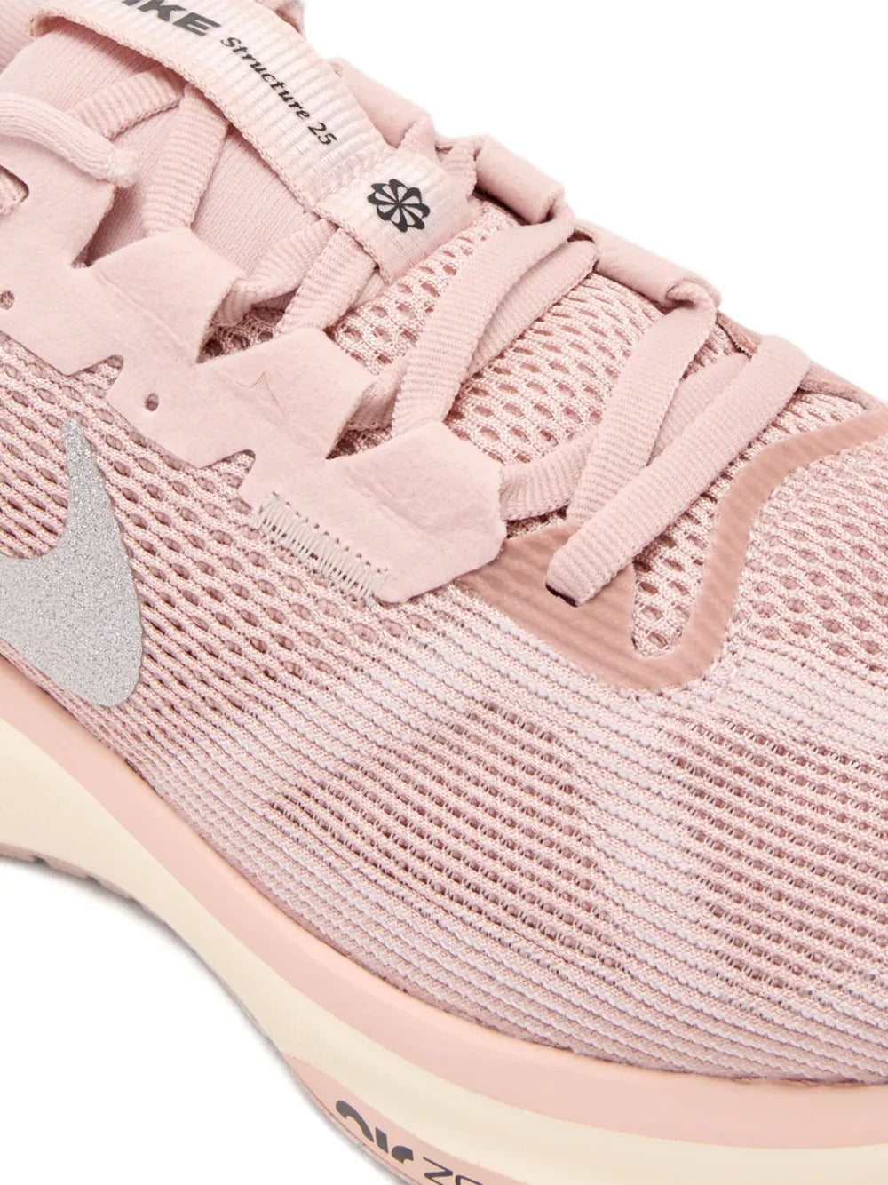 Close-up of pink knit running shoe with laces, Nike Swoosh, and Air Zoom detail