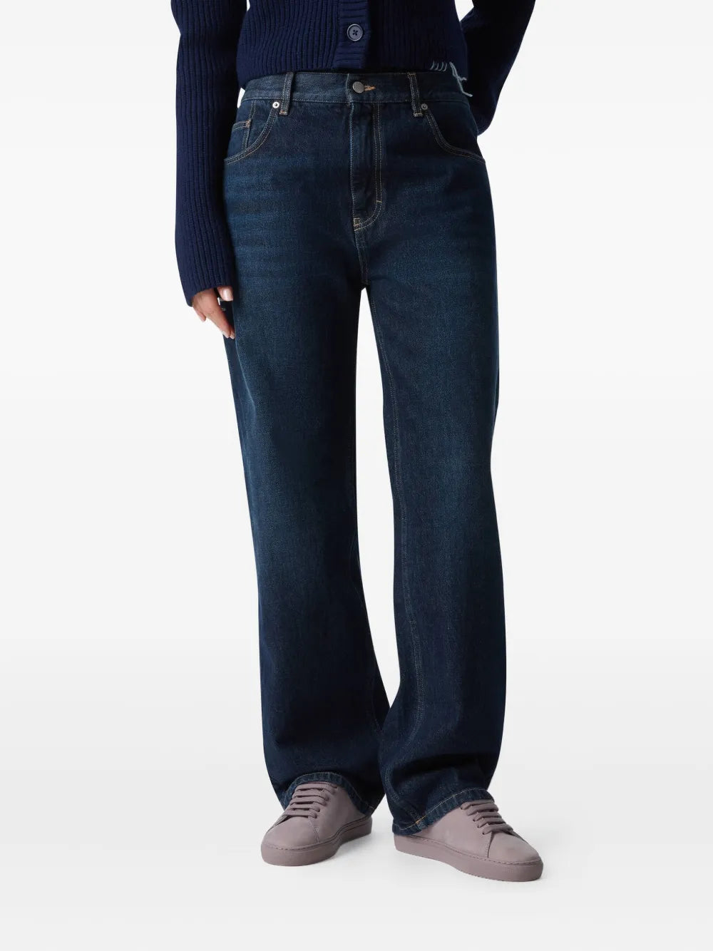 Mauve low-top suede sneakers worn with dark blue jeans
