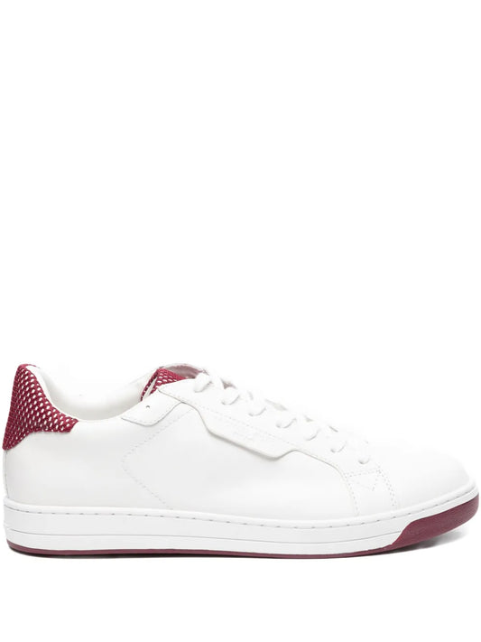 White low-top sneakers with red polka-dot heel, lace-up closure, rubber sole