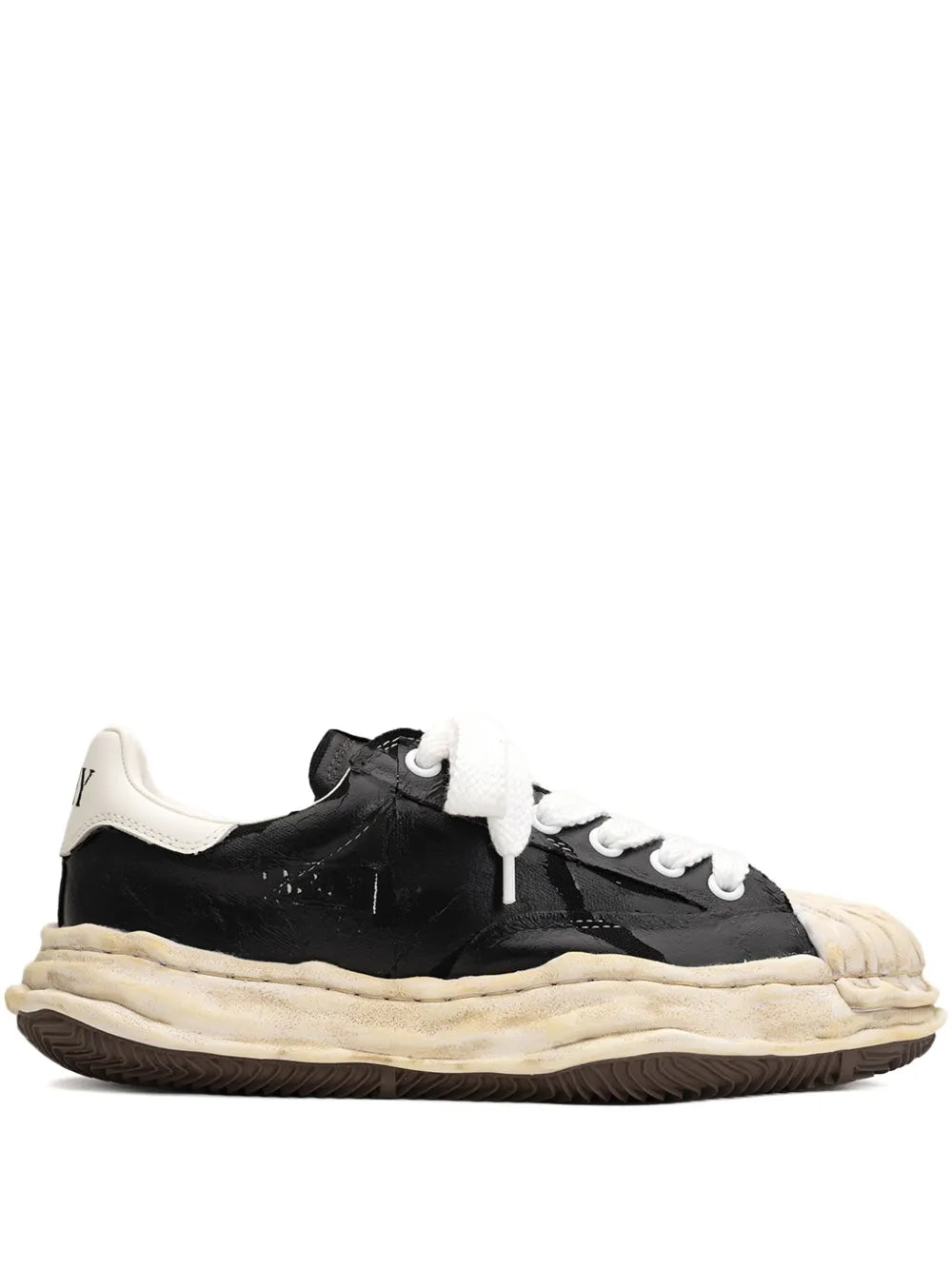 Black low-top sneakers with white laces and chunky cream rubber sole