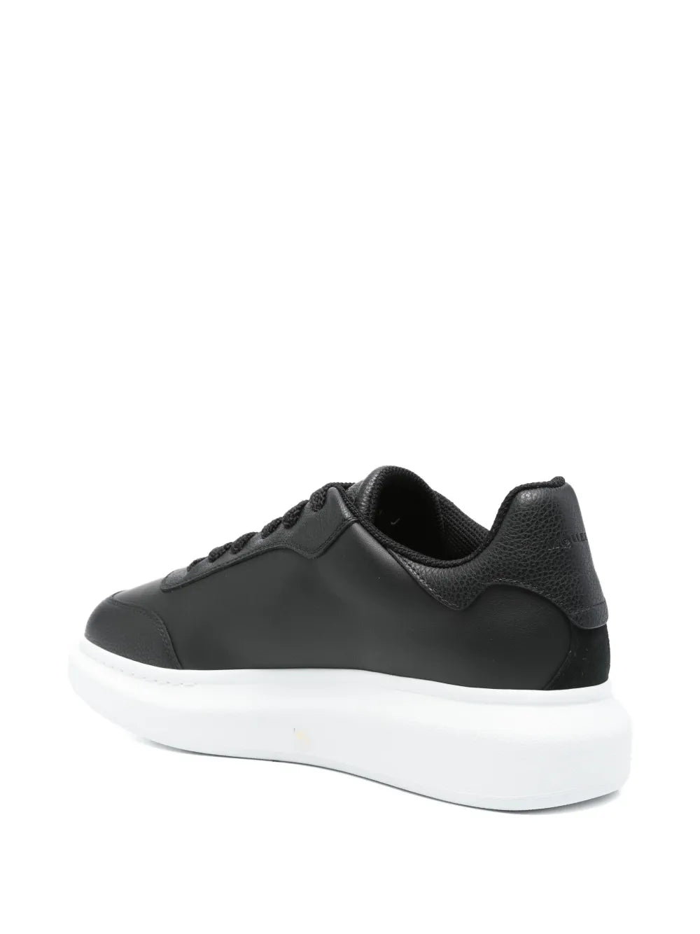 Black platform sneakers with embossed side logo, rear quarter view, white sole