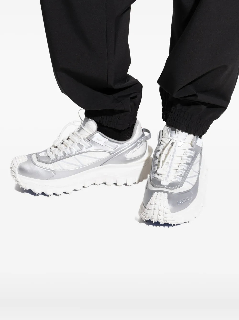 White Moncler Trailgrip GTX sneakers on feet, lace-up with blue-tipped tread