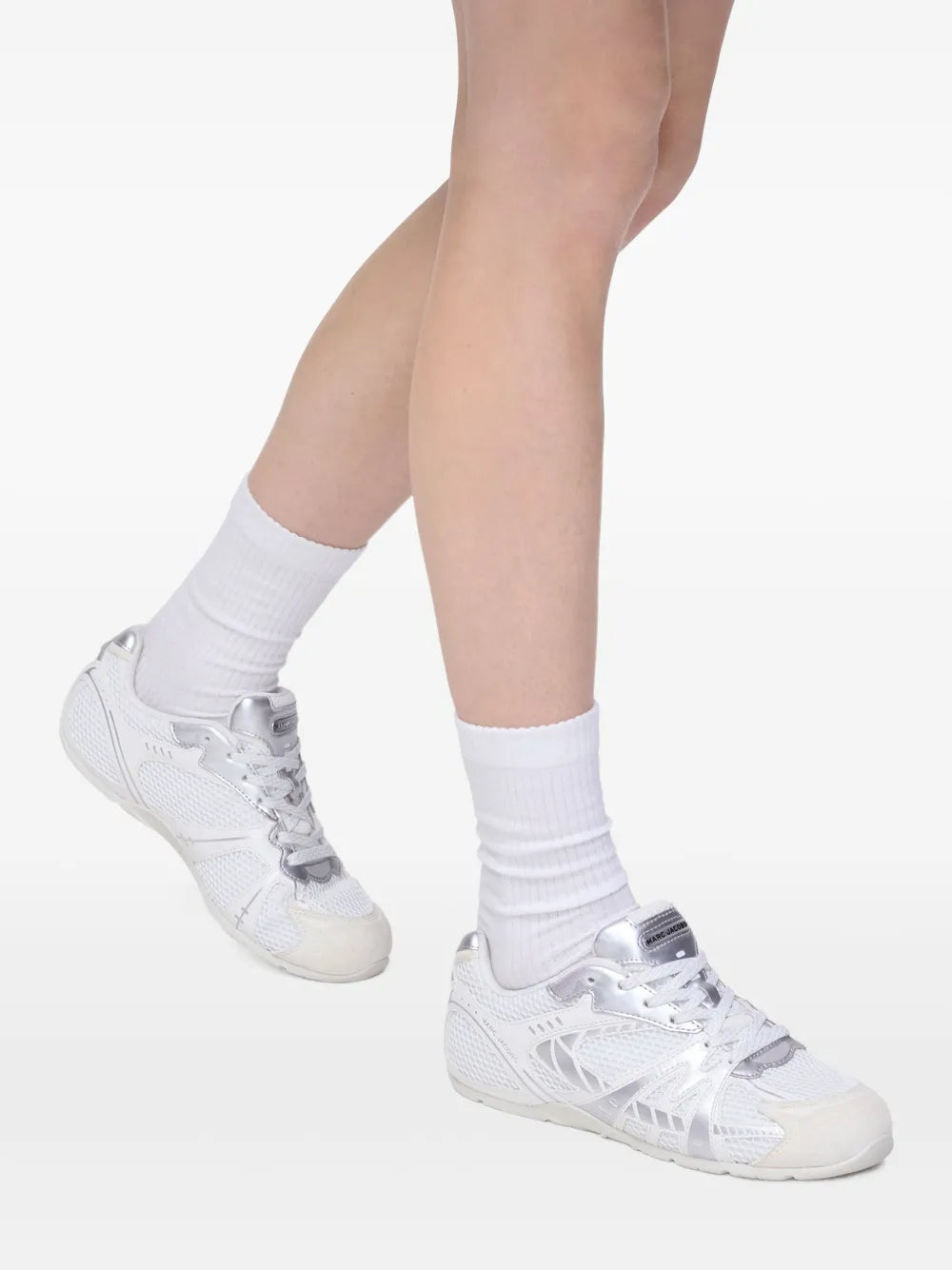 White mesh-panel lace-up sneaker on white socks, side profile
