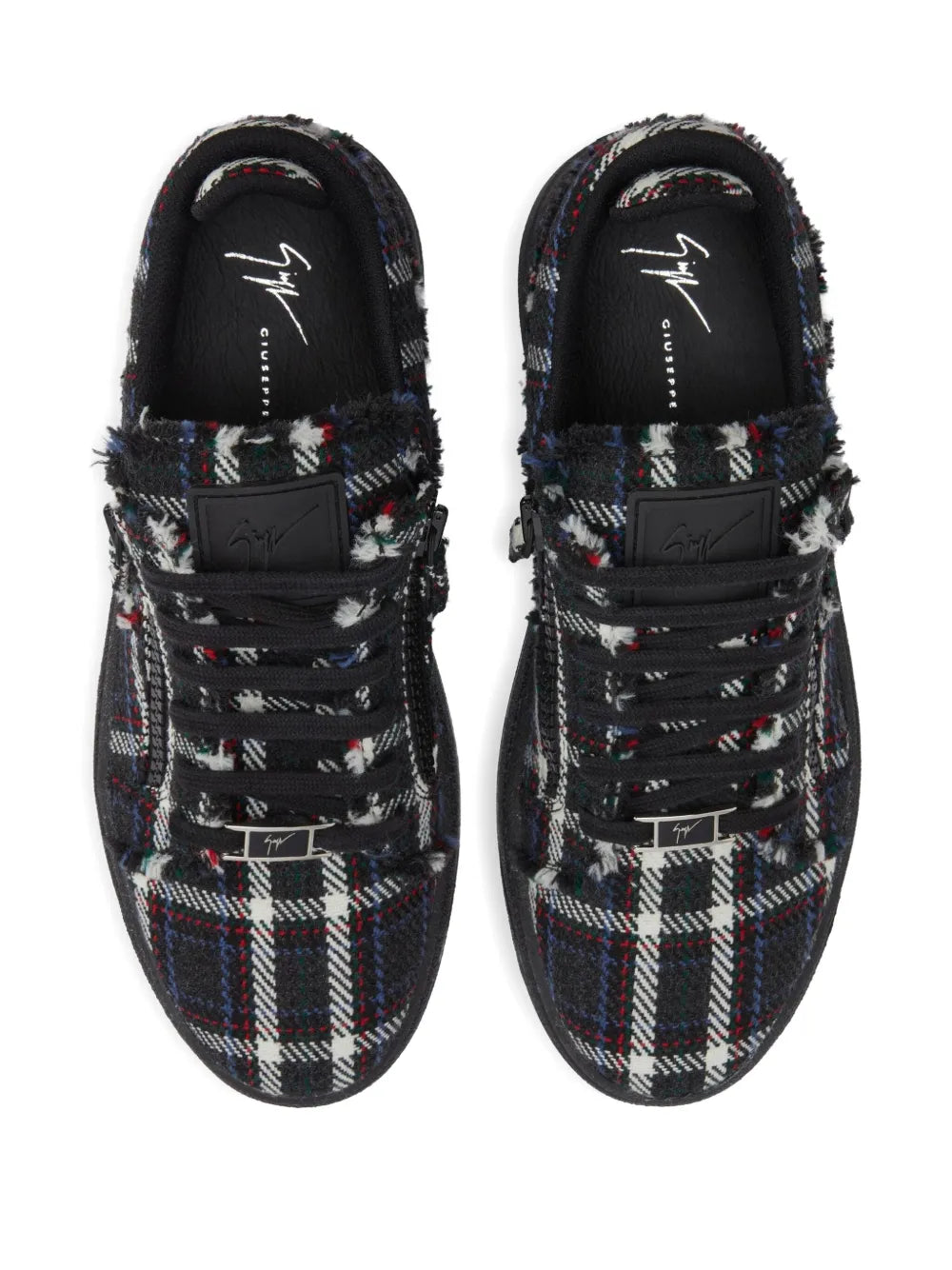 Top view of black low-top lace-up sneakers with multicolor plaid pattern and metal logo tag