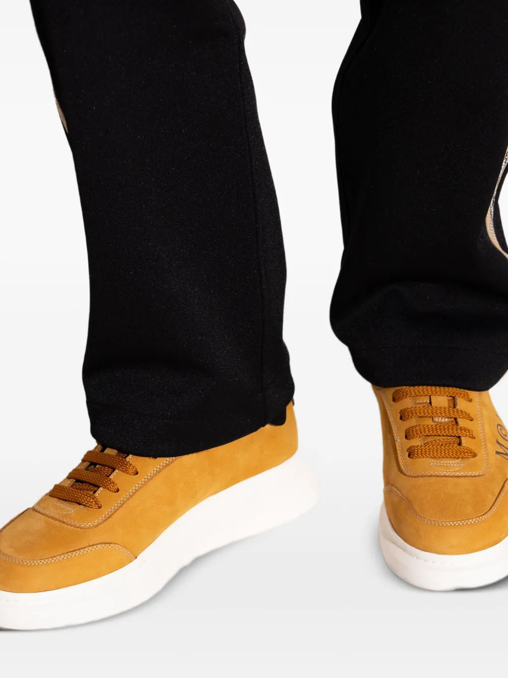 Golden brown lace-up sneakers with black panels and white platform sole