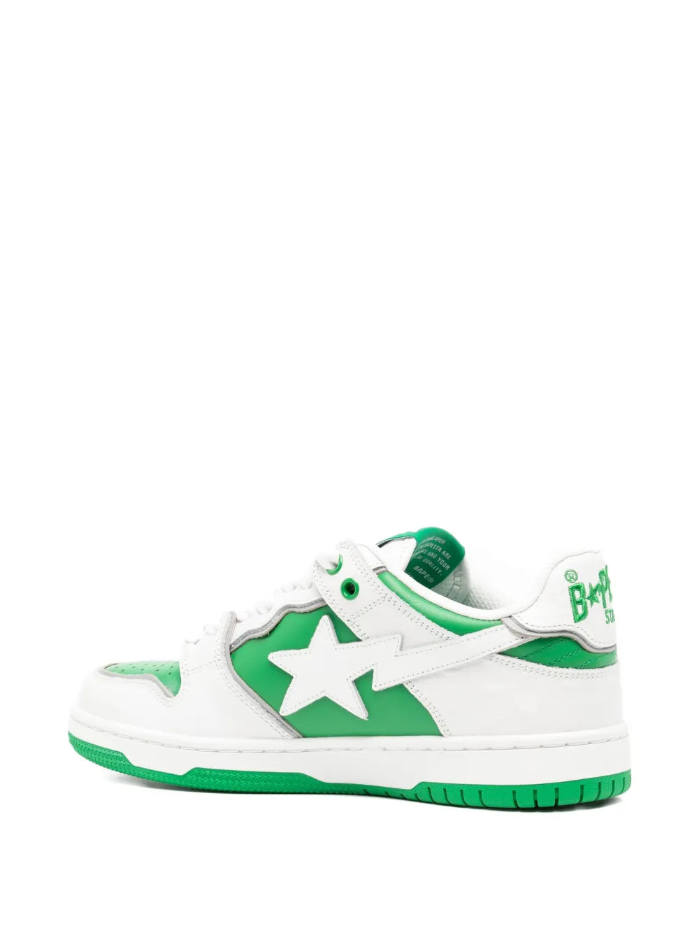 White low-top sneakers with green star panel and side logo detail, green sole