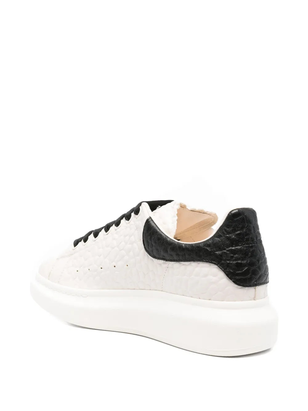 White textured sneaker with black heel panel and tan interior lining