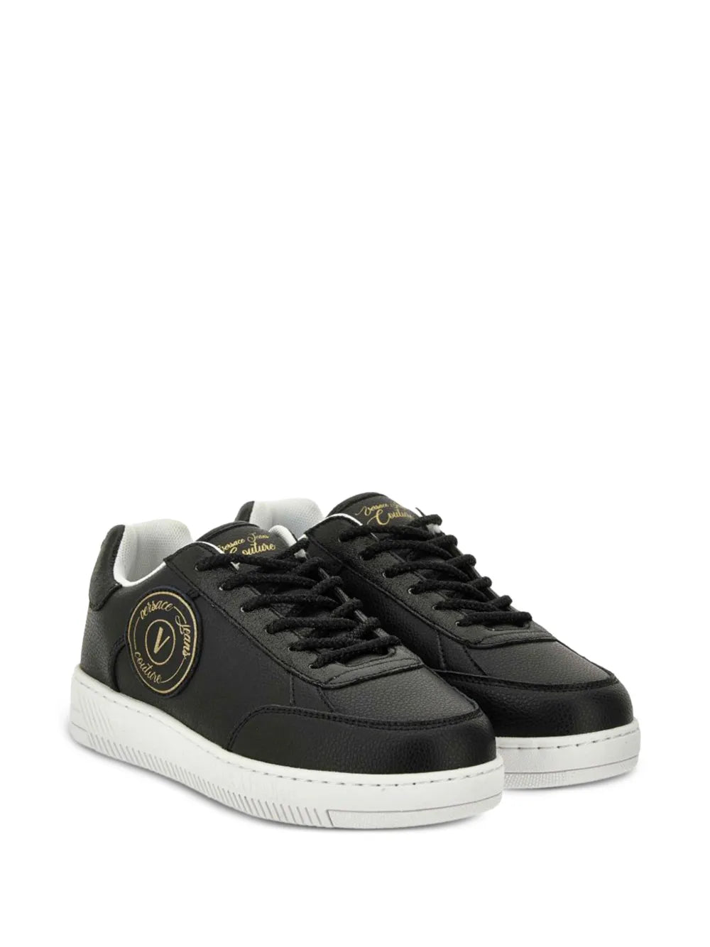 Black low-top lace-up sneakers with gold logo patch and textured white sole