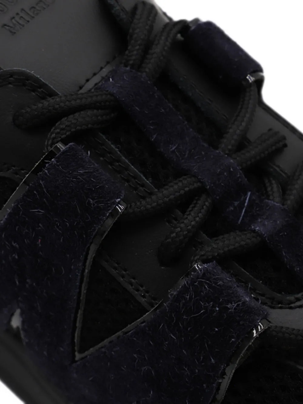 Moschino black suede sneaker upper close-up with lace-up eyelets