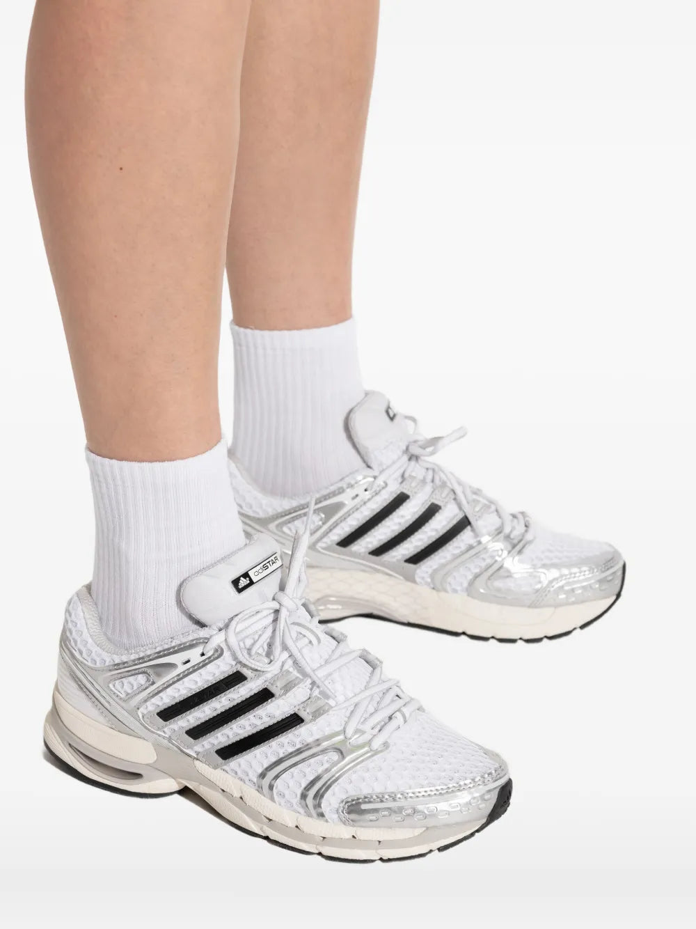 adidas running shoes on white socks, lace-up design with silver-gray upper and thick sole
