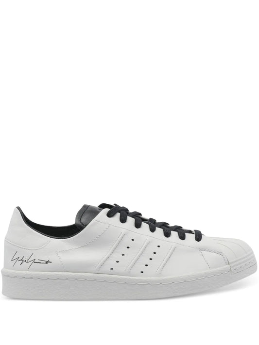 White leather sneakers with perforated logo and three stripes, black laces