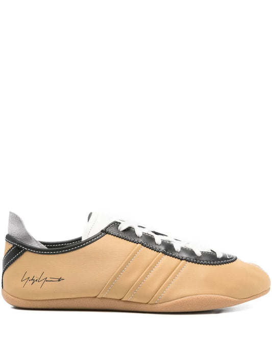Tan leather lace-up sneaker with black stripe detailing and white laces
