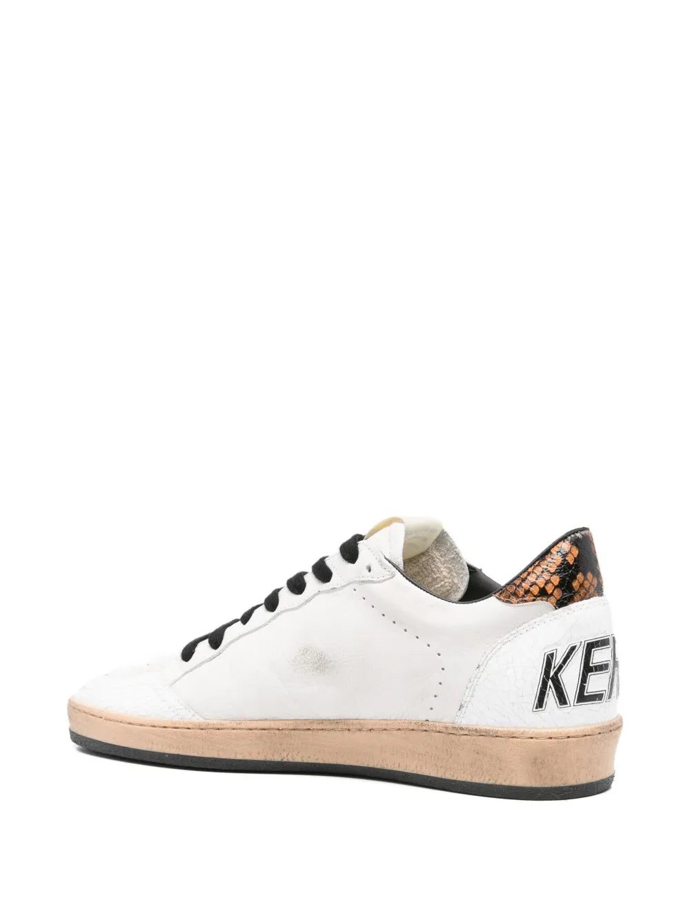 White low-top sneakers with snake-pattern heel, black laces, tan rubber sole