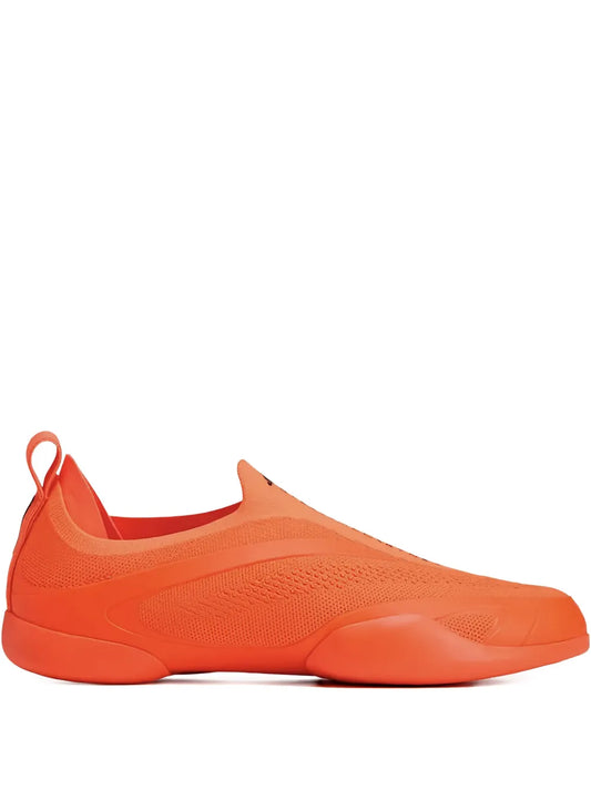 Orange slip-on taekwondo sneakers by adidas by Stella McCartney, side view