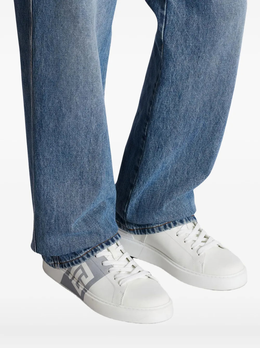 White calfskin sneakers with Balmain logo, worn with blue jeans