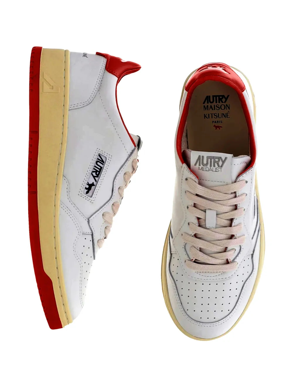 White leather low-top sneakers with red accents and tan rubber sole; lace-up pair