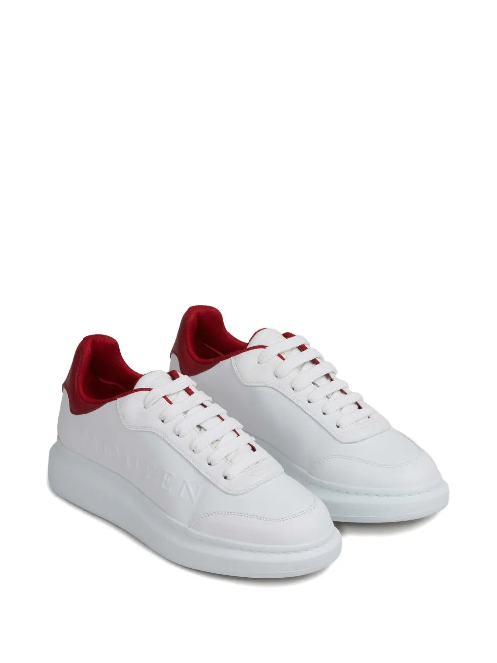 White lace-up trainers with red collar and chunky white sole