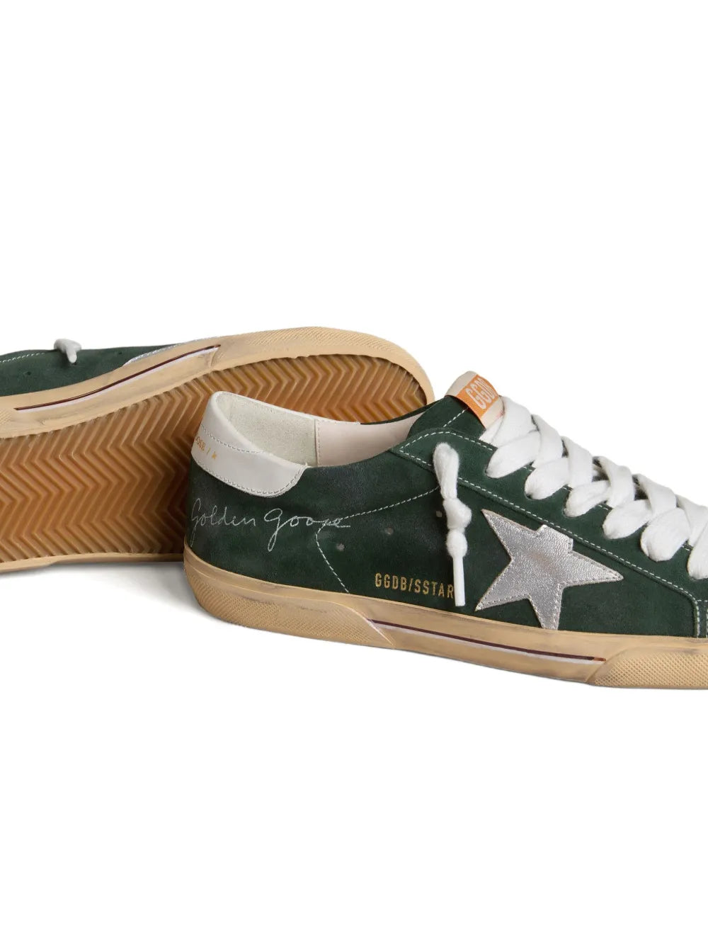 Green leather sneakers side view with white laces, silver star, visible gum outsole tread