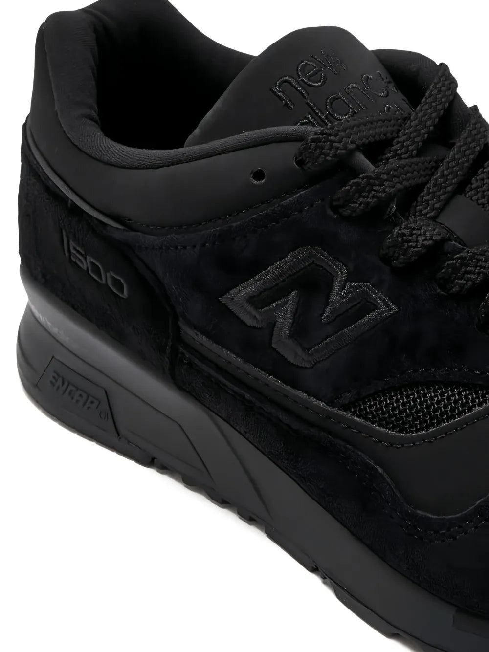 Black New Balance 1500 lace-up sneakers, close-up of N logo and laces