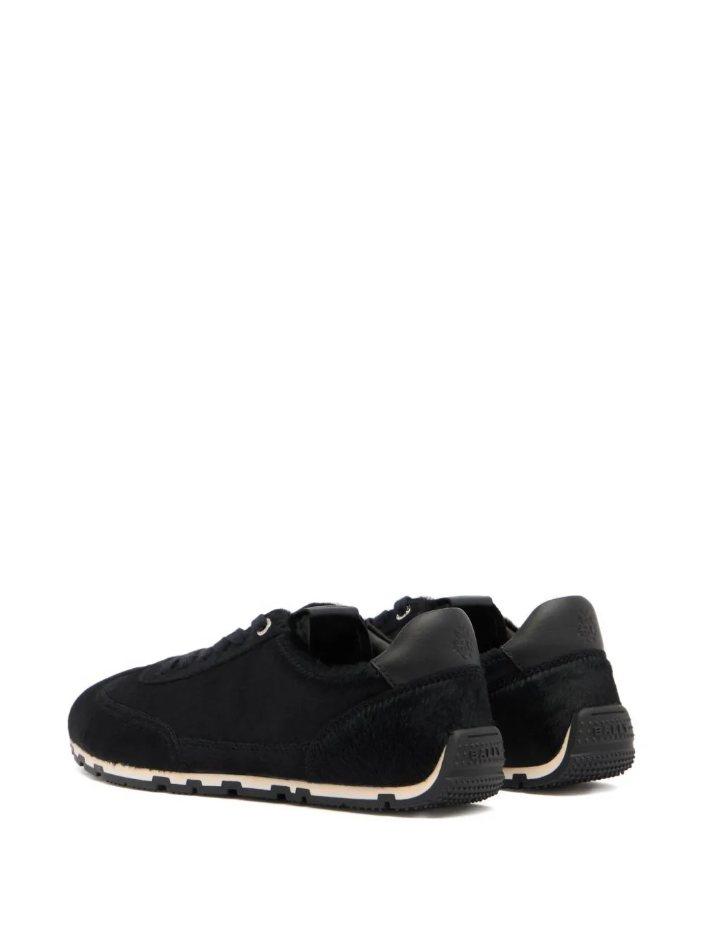 Black low-top sneakers in profile with lace-up design and chunky outsole