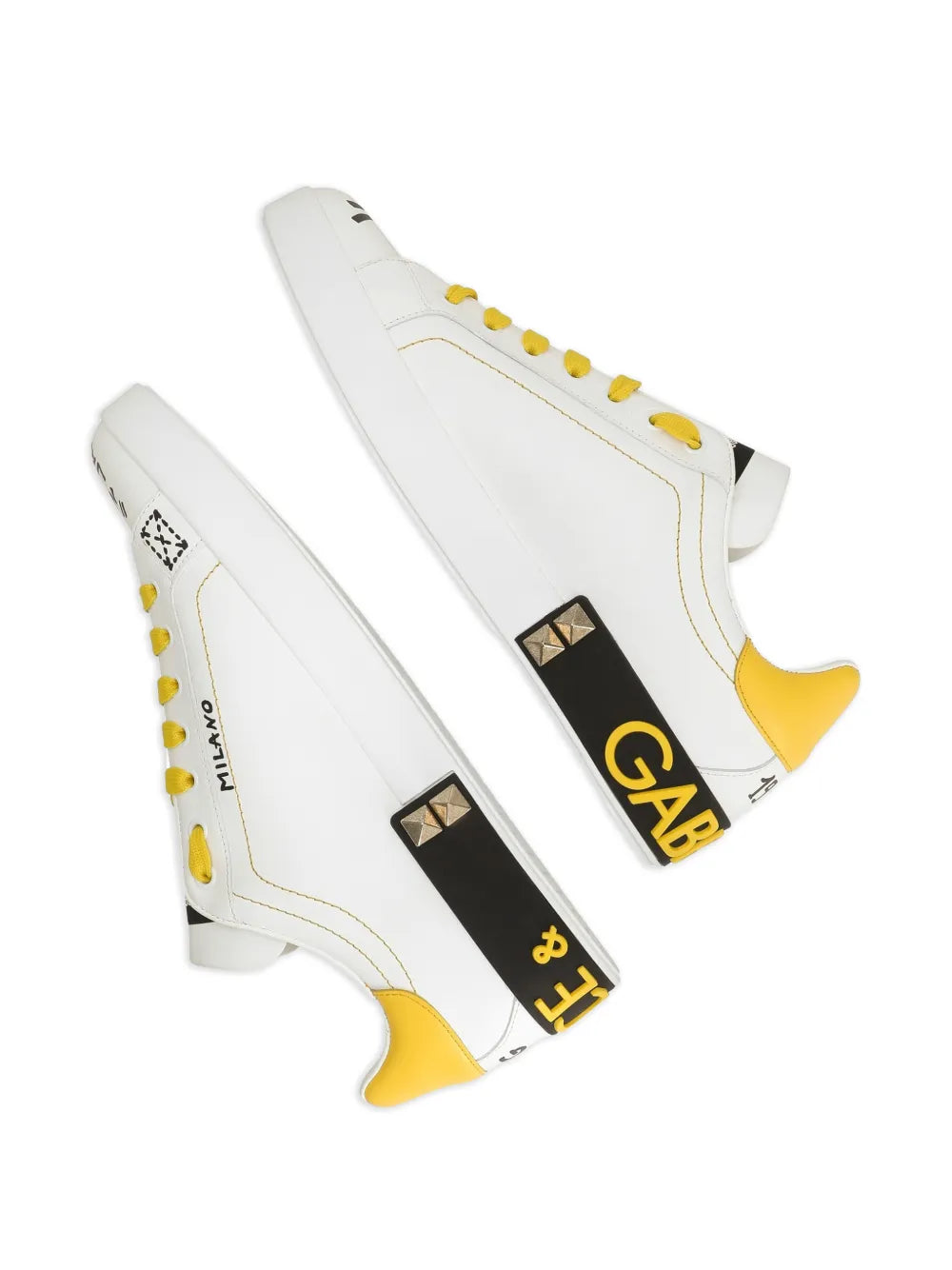 White Dolce & Gabbana sneakers with yellow laces, gold patch, and studded crown