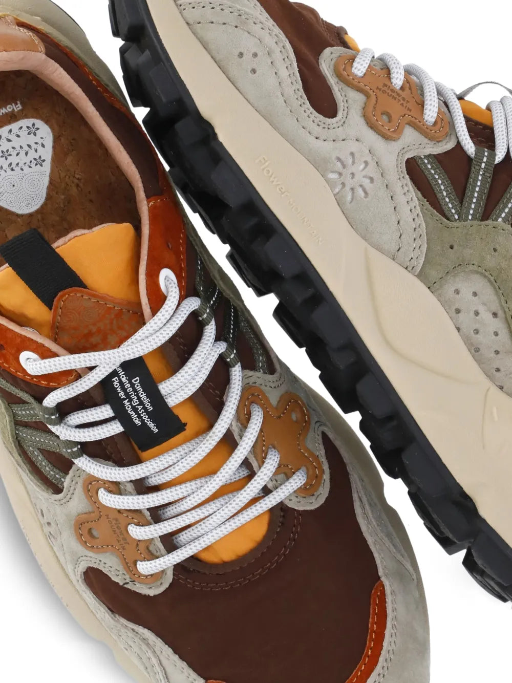 Close-up of multicolor leather lace-up trainers with white laces and textured panel details