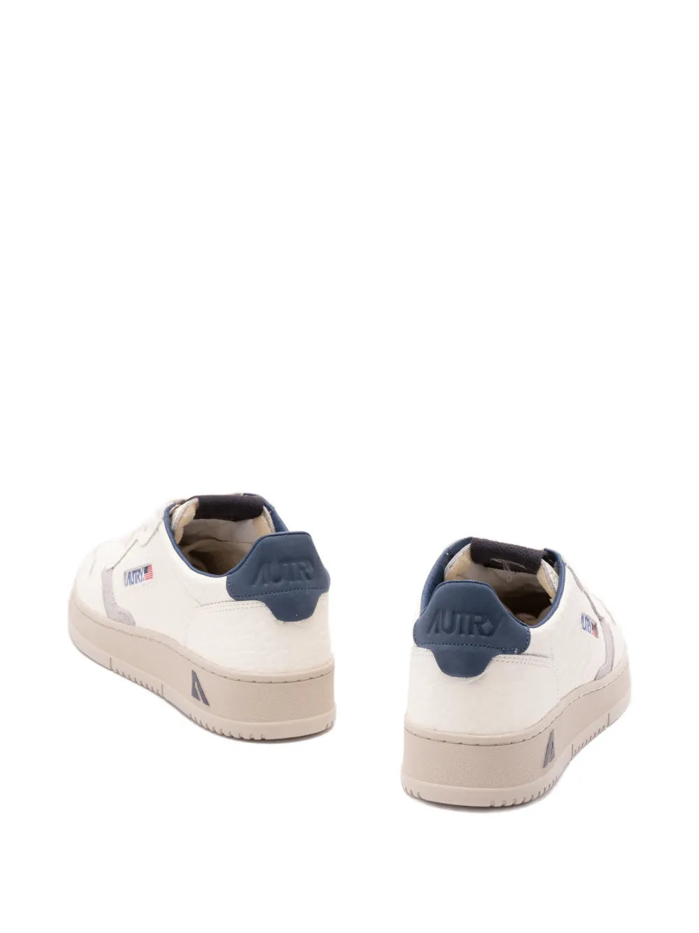 Light beige low-top sneakers with navy heel collar, rear view and side logo patch