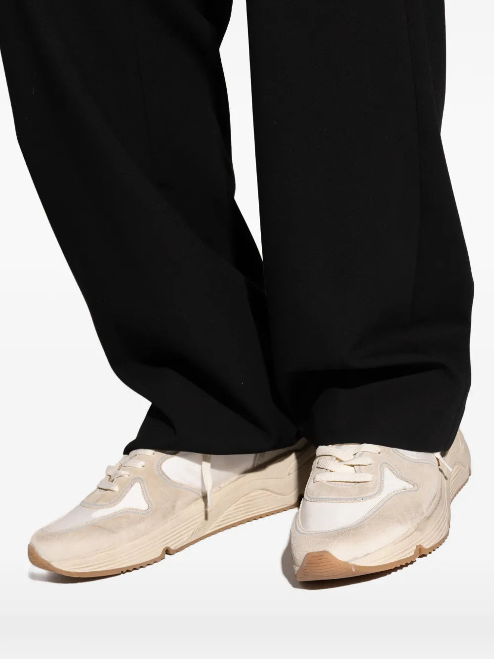 Golden Goose cream running sneakers worn with black pants and chunky sole
