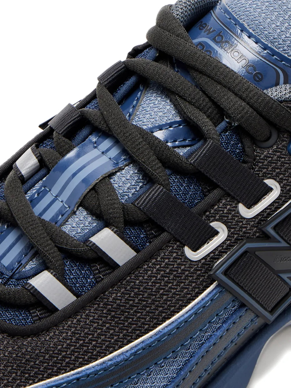 Close-up of blue and dark gray sneakers with New Balance logo plaque and lace straps