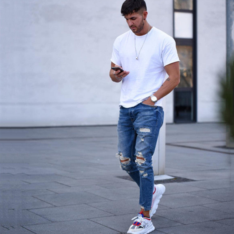 Men's deep blue ripped jeans with distressed knee patches and frayed rips
