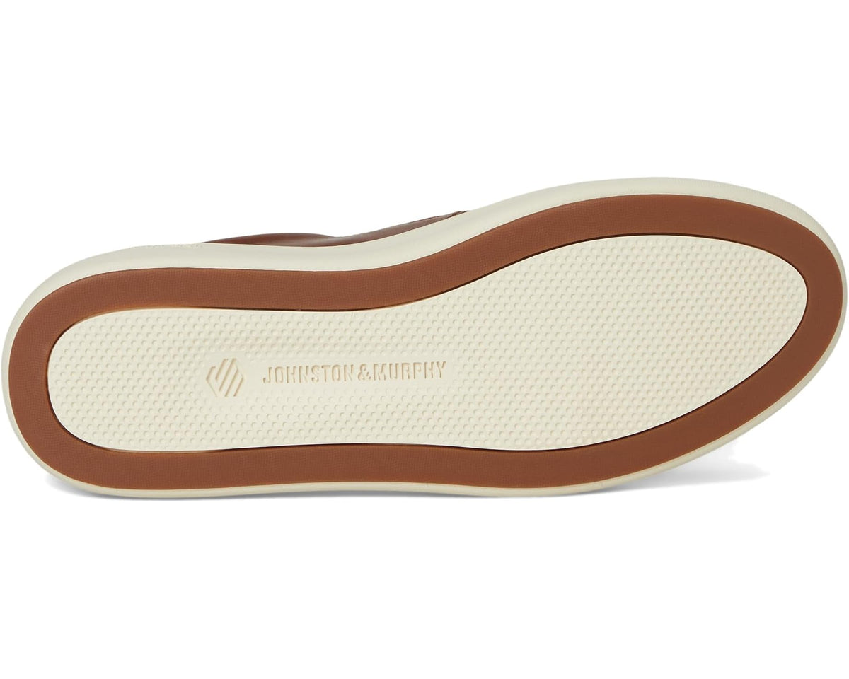Outsole view of tan-brown slip-on leather sneaker with textured tread
